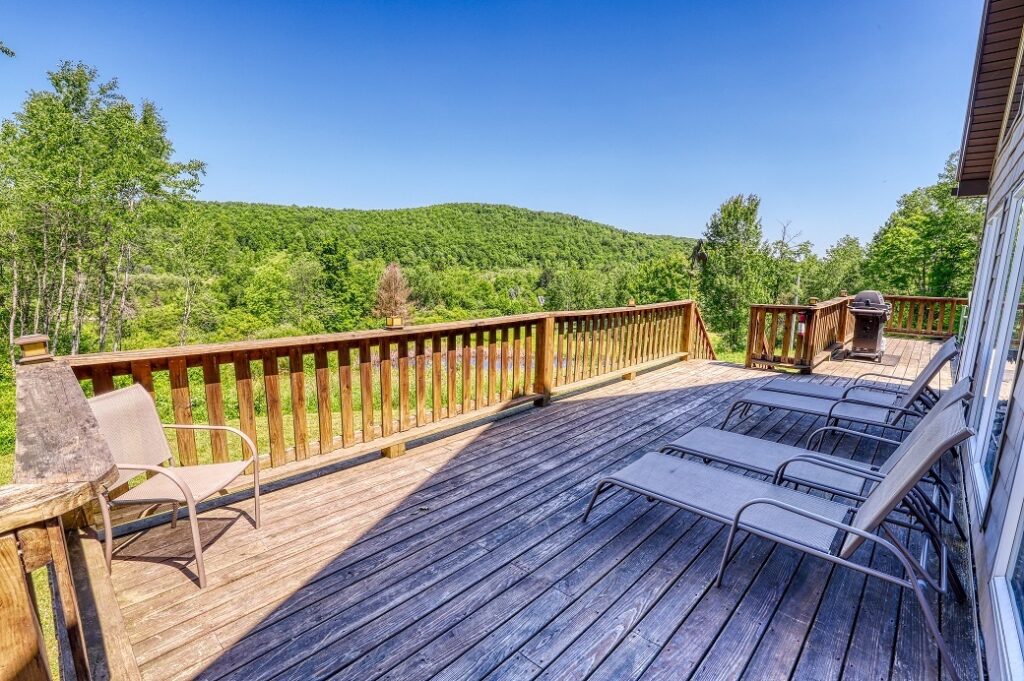 lounge chairs on deck with view of trees roosters den